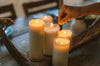 Candles being lit on a wood table