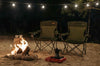 Two camping chiars next to a campfire