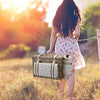 girl walking natural wicker picknic basket with blanket and wine