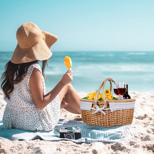 wicker picknic basket with white cloth insert on beach
