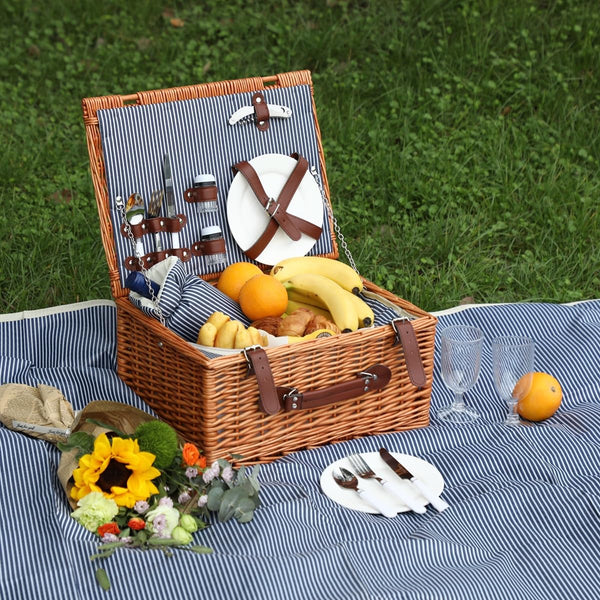 wicker picnic basket open on blue stipe picnic blanket