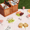 brown natural wicker picnic basket on pink and white blanket