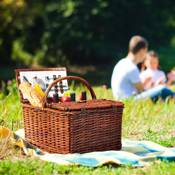 brown wicker picnic basket on yellow and blue blanket