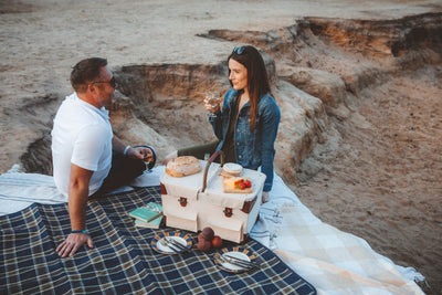 canvas white picnic basket for two closed on blanket at beach