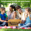 closed wicker picnic basket on grass with family