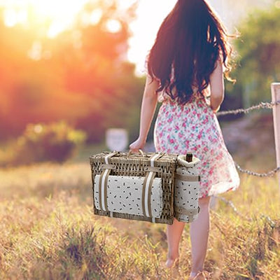girl walking natural wicker picknic basket with blanket and wine
