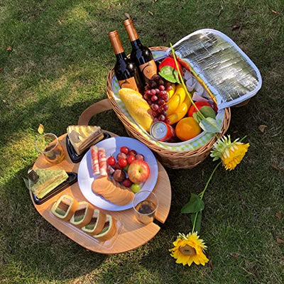natural wicker picnic basket with mini table on grass with food