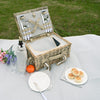 open picknic basket for 2 people on white blanket