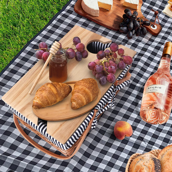 picknic basket on blue and white mat with food