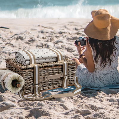 tan wicker picnic basket on sand at the beach closed