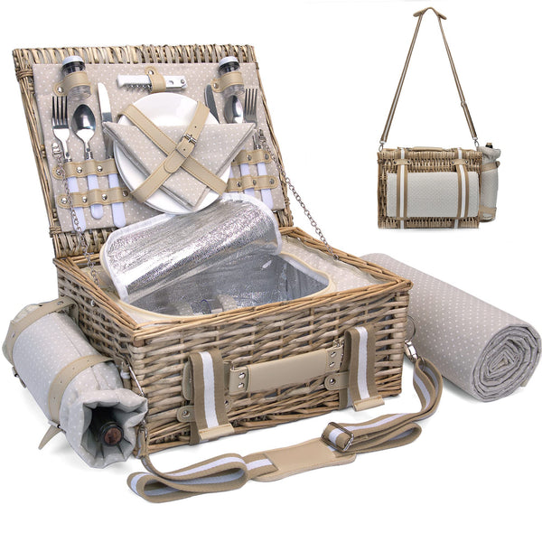tan wicker picnic basket open on table with blanket and utensils