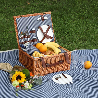 wicker picnic basket open on blue stipe picnic blanket