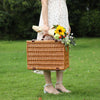 woman carrying a brown wicker picnic basket